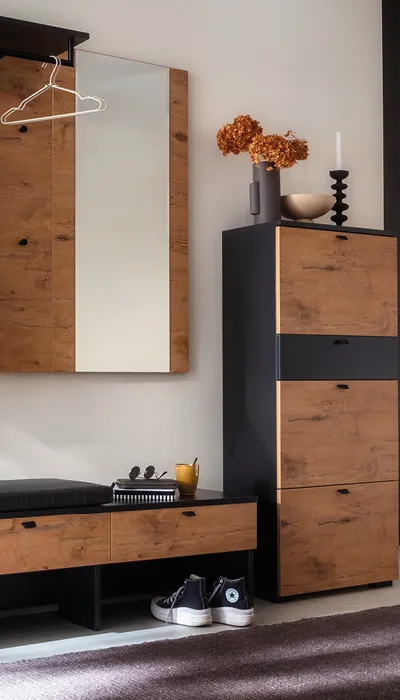 Moderner Eingangsbereich mit Garderobenschrank, Spiegel, Sitzbank und Stauraum in trendiger Holz-Schwarz Kombination, dekoriert mit Trockenblumen und Accessoires für stilvolle Flurgestaltung.